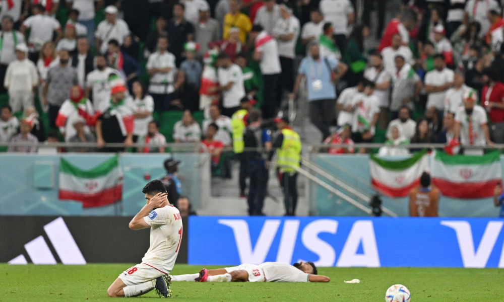 Meio-campista iraniano Ali Karimi e o zagueiro iraniano Ramin Rezaeian após a partida entre Irã...